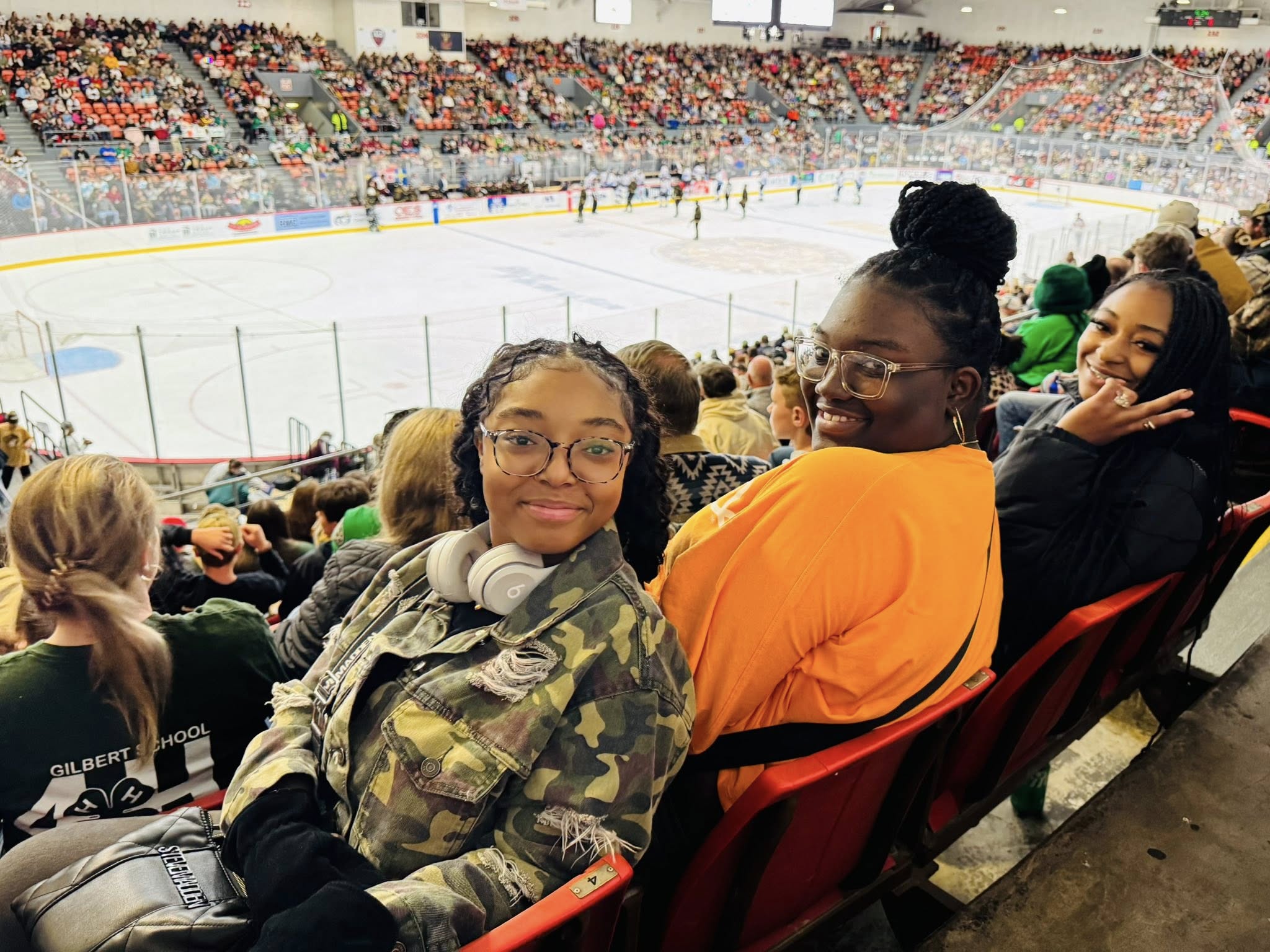 Three girls at a hockey game.